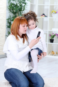 Mom & child receiving a text-Shutterstock