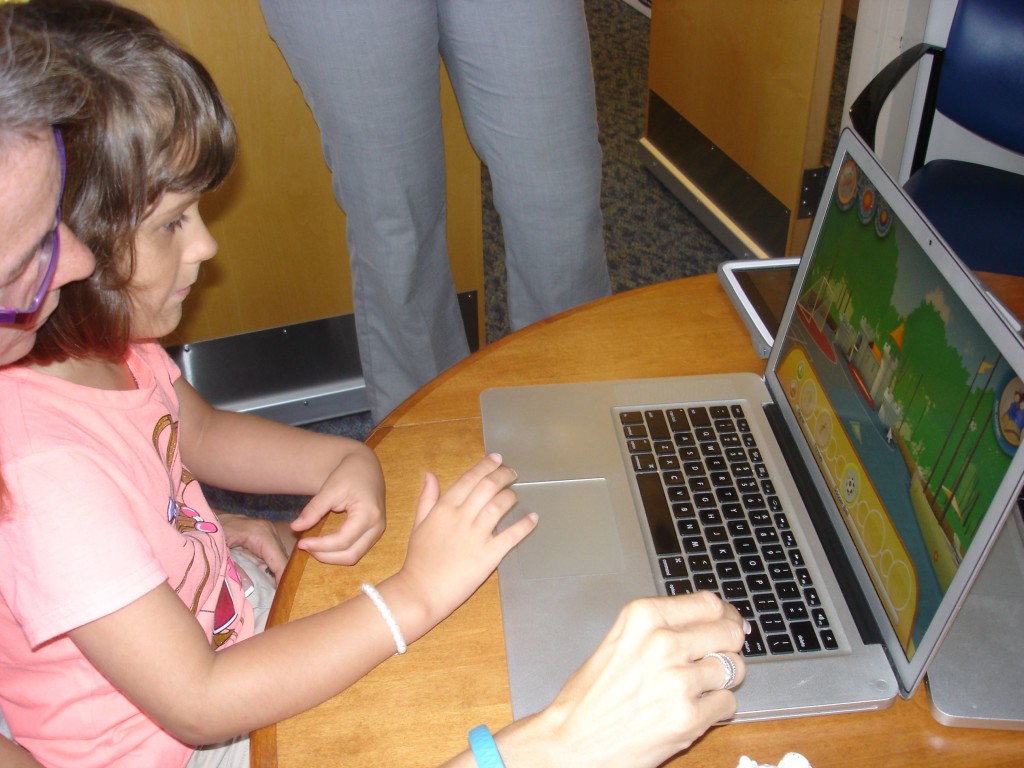 With initial help from her mother, Kailee West, 6, quickly masters the basics of Puddingstone Place, an interactive virtual environment that helps children with autism develop language skills.